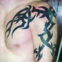 Black tribal tattoo on chest and shoulder