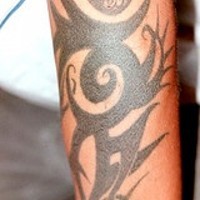 Black sign tribal arm tattoo