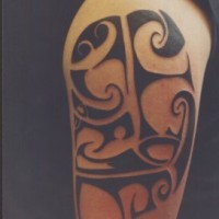 Interesante tatuaje estilo tribal en tinta negra en el hombro