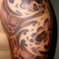 Brown tribal shoulder tattoo with skulls