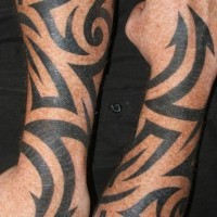 Tatuaje en tinta negra en las mangas estilo tribal