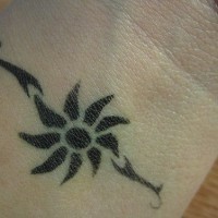 Tribal sun tattoo on wrist