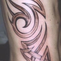 Tatuaje estilo tribal en color marrón en el costado