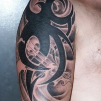 Shoulder tattoo with black tribal sign