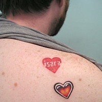 el tatuaje de tres corazones rojos hecho en la espalda