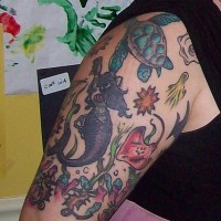 Tattoo von Meeresnixe und Schildkröte am Oberarm
