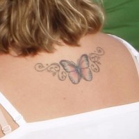 Kleiner Schmetterling auf Tattoo am oberen Rücken