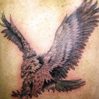 Le tatouage de haut du dos avec un aigle volant agressif