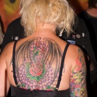 Beautiful roses on upper back in winged web tattoo