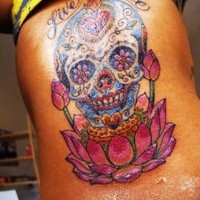 Tattoo mit kleinem freiem Schädel in Blumen am oberen Rücken