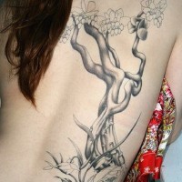 Precioso tatuaje del árbol con flores en la espalda