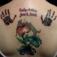 Le tatouage sur le haut du dos avec des empreintes de mains et des chats près de fleurs