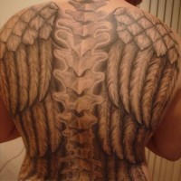 Backbone  tattoo on upper back with wide wings