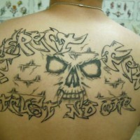 Le tatouage de haut du dos avec le visage de la crâne et une inscription
