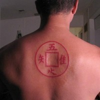 Rotes Tattoo mit Quadrat und Hieroglyphen am oberen Rücken