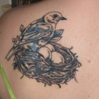 Le tatouage de haut du dos d'un oiseau avec des œufs dans le nid