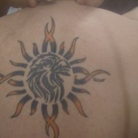 Tatuaggio colorato sulla schiena il disegno in forma di sole con la testa dell'aquila in dentro