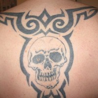 Le tatouage tribal de haut du dos avec une crâne stylisée