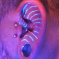 Ultraviolet ink tattoo in ear