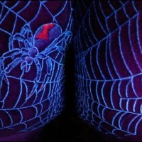 Spider in web glowing tattoo