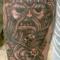 Tattoo of viking head with dark eyes and skulls