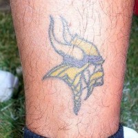 Kleiner Wikingerkopf Tattoo am Bein