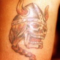 Tatuaje del cráneo del viking con el casco y la treza