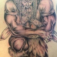Gran tatuaje el viking inclinado con los brazos cruzados
