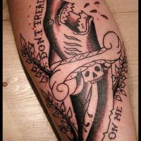 Tatuaje en la pierna con el tiburón furioso y una inscripción  