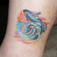 Tatuaje la orca saltando al fondo de la puesta del sol