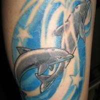 Two dolphins in blue waves decorated with stars tattoo