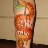 Tatuaje gran serpiente matado con tridente en la pierna