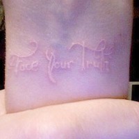 White ink tattoo with inscription on wrist