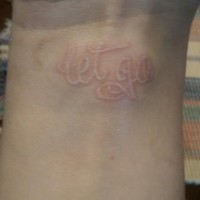 White ink wrist tattoo with inscription let go