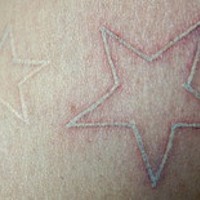 Tatuaje dos estrellas pequeñas en tinta blanca