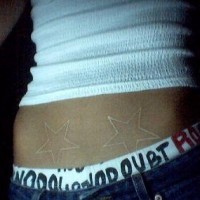 White ink tattoo with two stars on lower belly