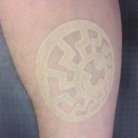 White ink tattoo with circle sign