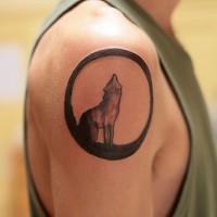 Tattoo with howling wolf in a circle