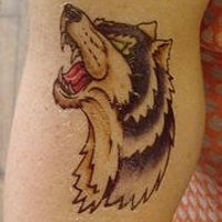 Heulender Wolf Tattoo in einem cartoonischen Stil