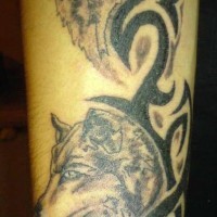 Tattoo with two wolves and a tribal sign