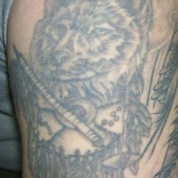 Gros tatouage sur l'épaule avec un loup et décoration