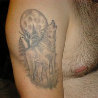 Tattoo an der Schulter mit heulendem Wolf auf Mond