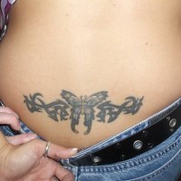 Simple tatuaje en el bajo de la espalda, en tinta negra, mariposa con tracería