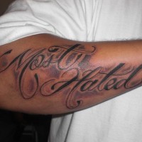 Most hated black styled  inscription forearm tattoo