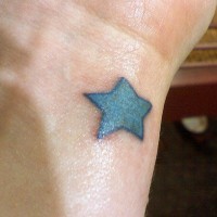 Pequeña estrella azul tatuaje en la muñeca