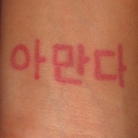 Jeroglíficos coreanos en tinta roja tatuaje en la muñeca