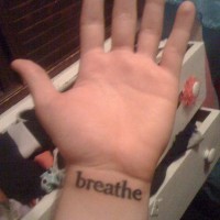 Breathe writing on wrist tattoo
