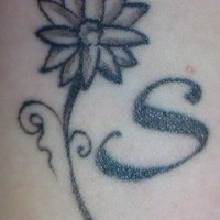Tatuaje en la muñeca la flor con letra S en negro y blanco