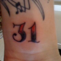 Número 31 en tinta negra y roja tatuaje en la muñeca