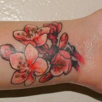 Simpático tatuaje en la muñeca con flor en color rosado